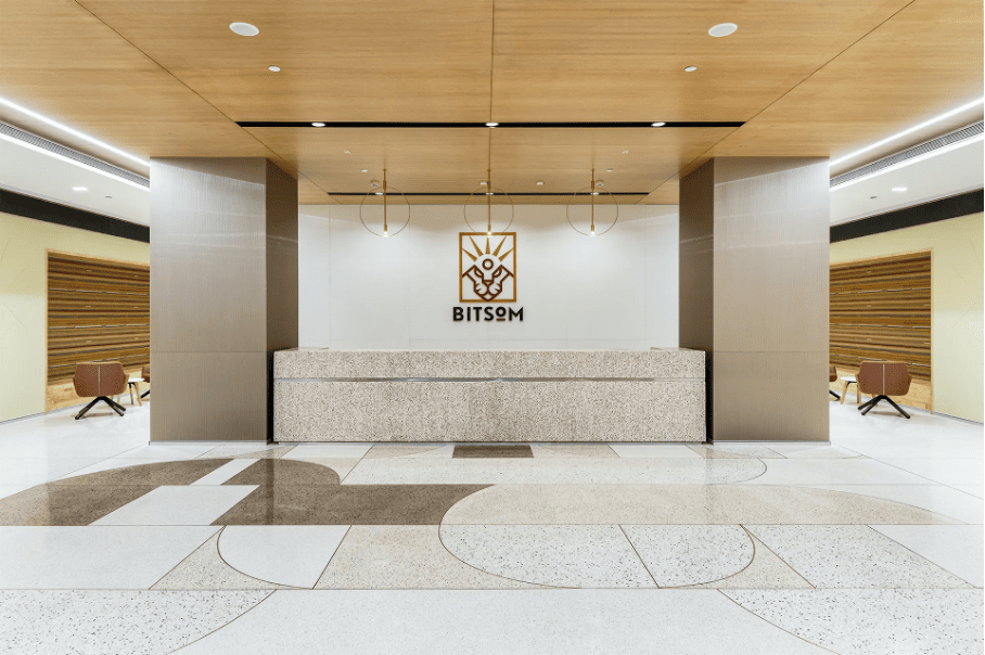 Elegant reception area of BITSOM, featuring a clean design, the institute's logo, and modern interiors.