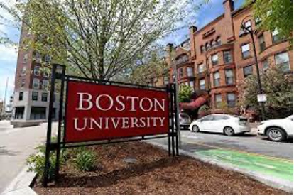 Entrance sign of Boston University with campus buildings in the background