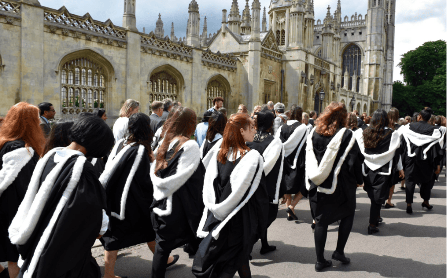Cambridge Judge MBA graduates in traditional gowns walking in procession