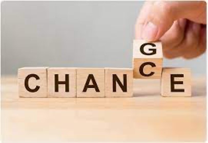 Hand switching blocks from 'CHANCE' to 'CHANGE' symbolizing strategy shift for GMAT 2023