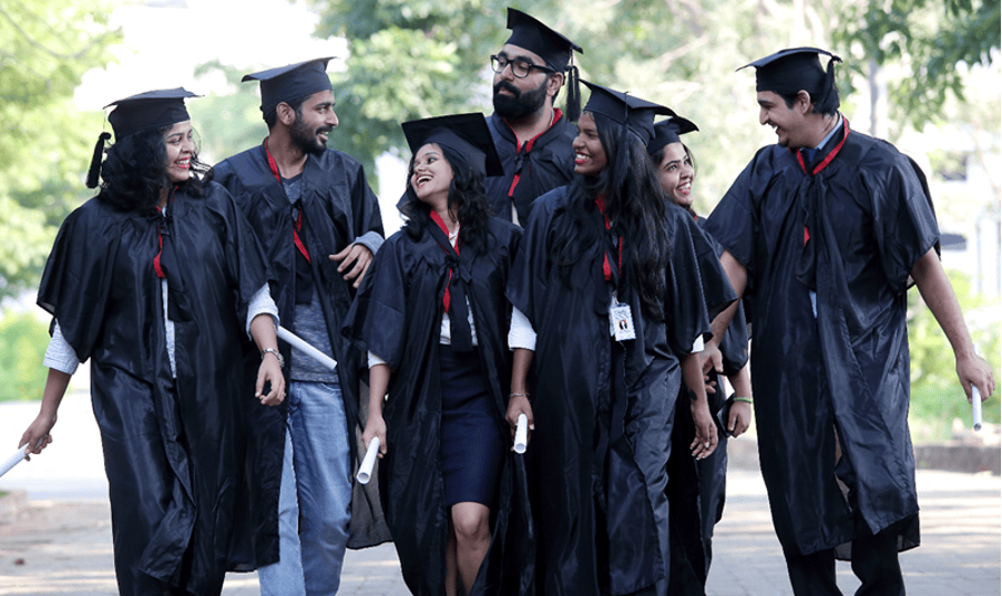 Group of happy graduates walking together in their graduation robes