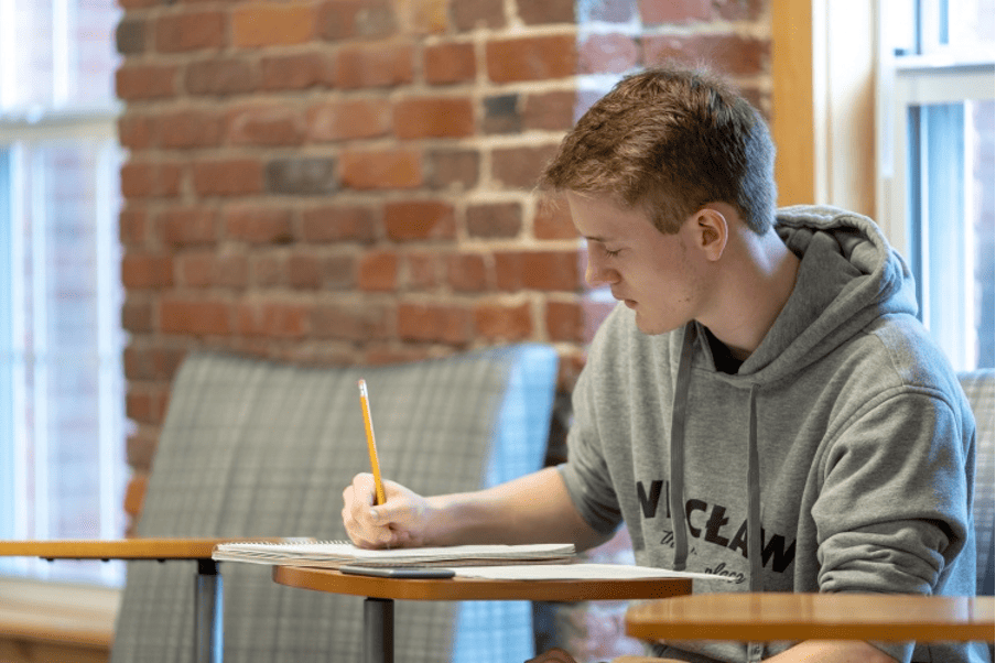 Kellogg student deeply engrossed in study within a comfortable campus setting