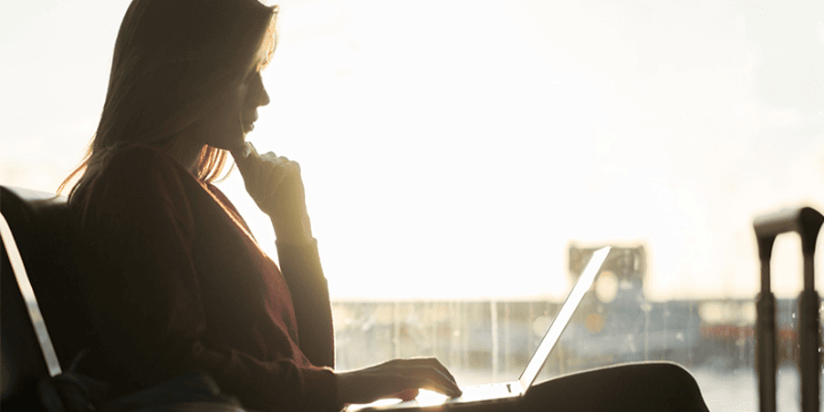 MBA applicant working on laptop with sunset backdrop