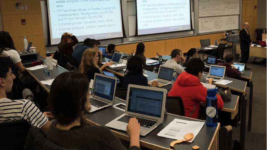 MBA students interacting in a classroom with a professor