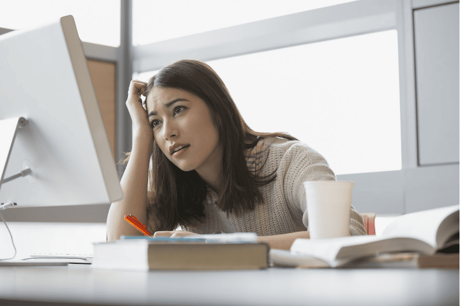 MBA student contemplating while studying at a desk