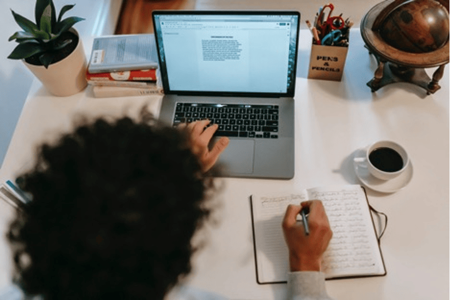 MBA student studying on a laptop with notes and coffee