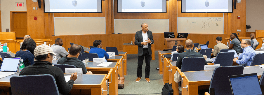 MBA students engaged in a classroom session with a professor at Tuck School of Business